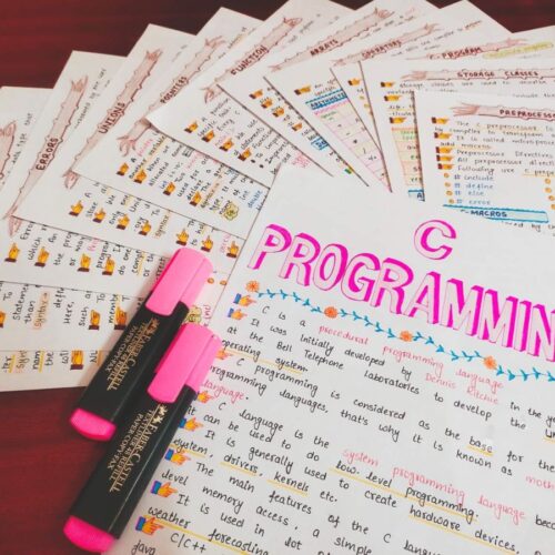 c programming first page with headings of all topic in sample 4 with pink Highlighters include in photo of physical copy kept on wooden desk